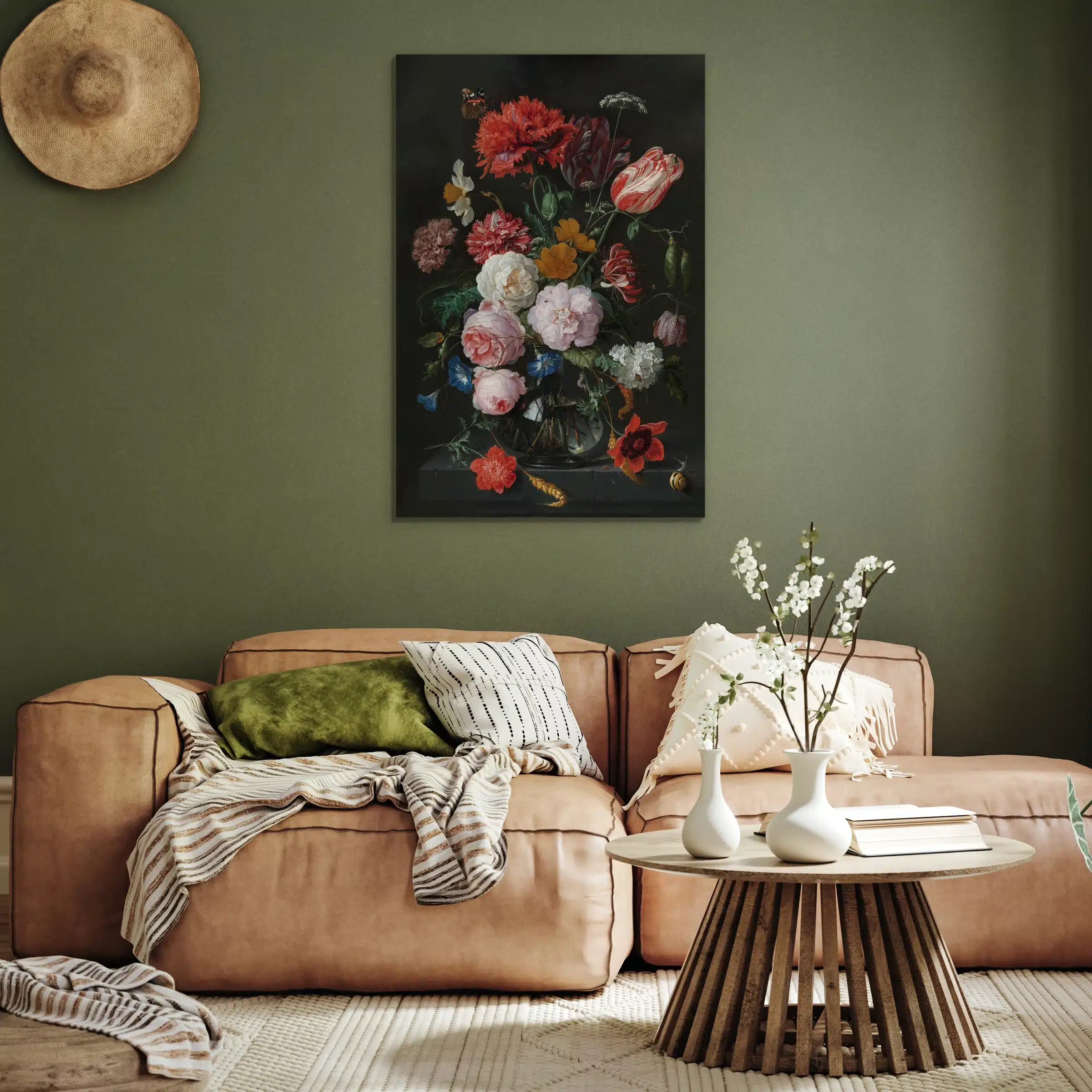 Stilleven met bloemen in een glazen vaas aan een olijfgroene muur boven een cognac leren bank