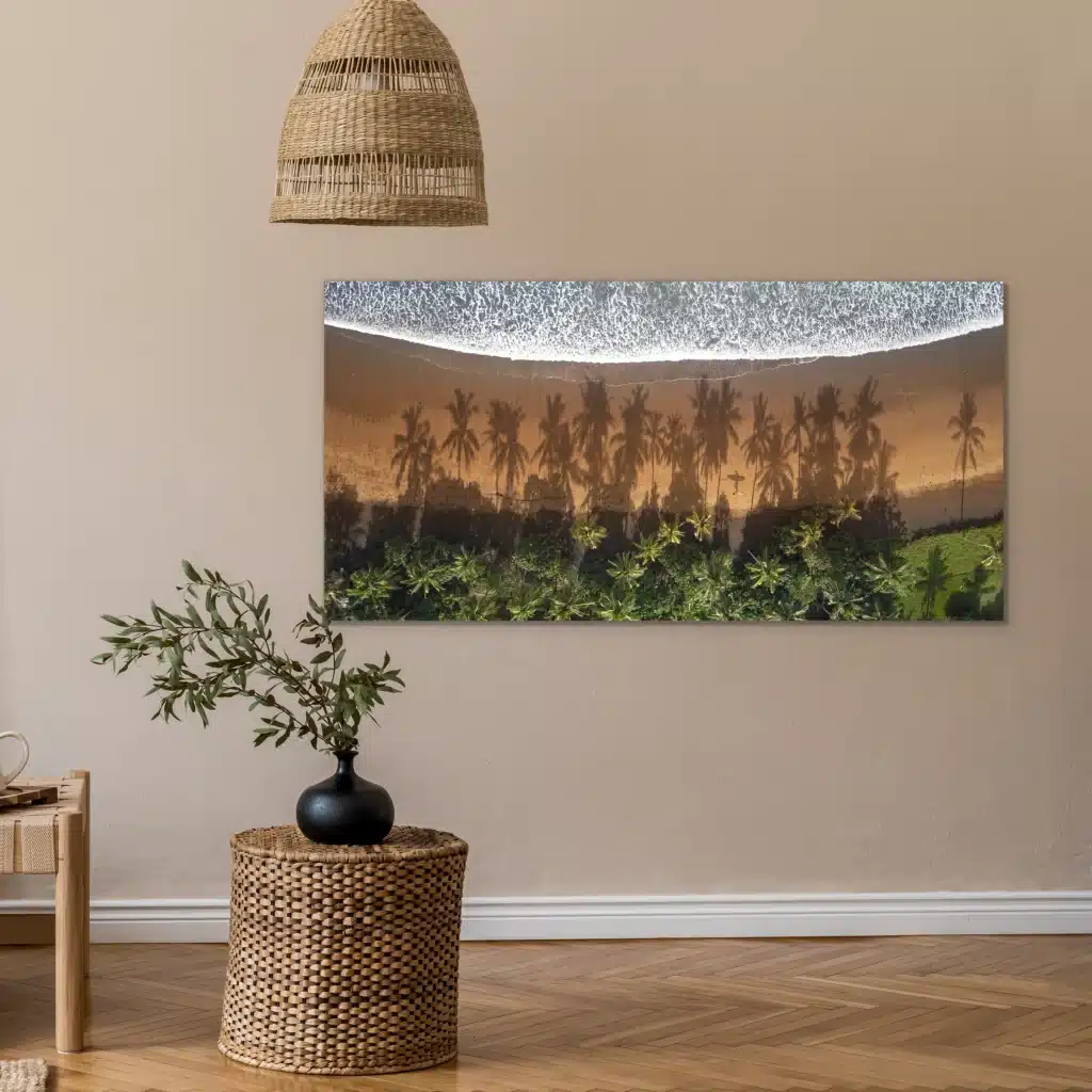 Strand van bovenaf aan een beige muur onder een rieten hanglamp, met een rieten bijzettafel