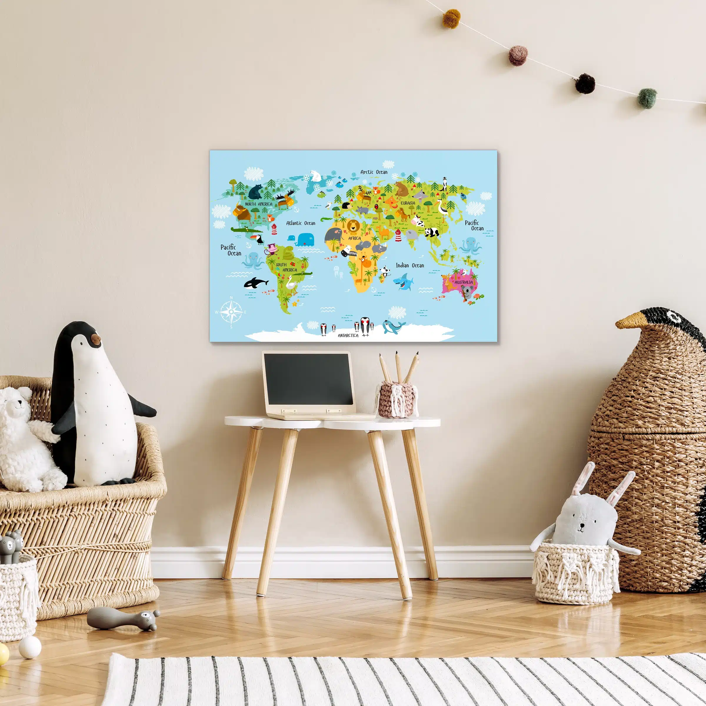 Wereldkaart dieren in kleur boven een kinderbureautje naast een knuffelpinguïn