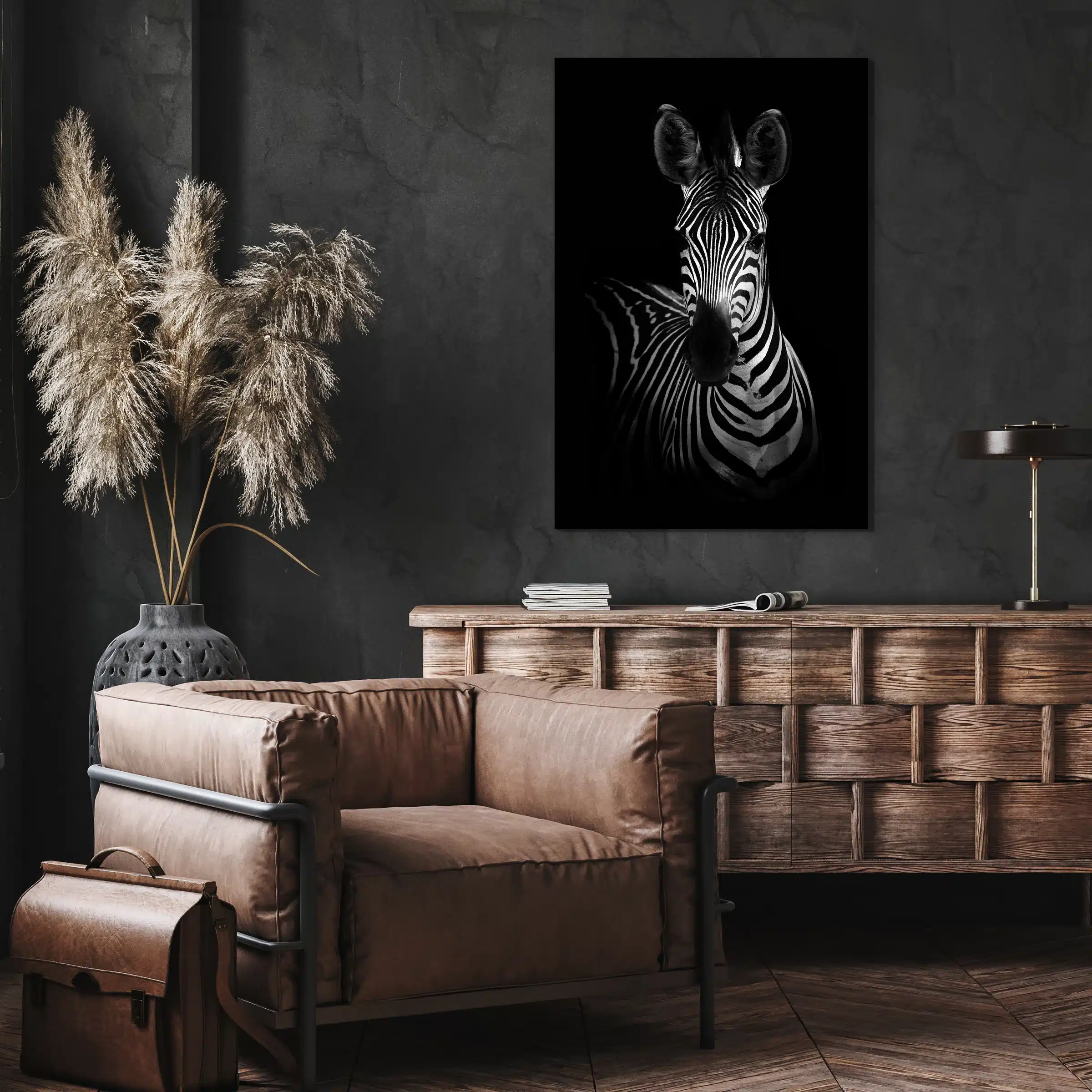 Zebra portret aan een donkere muur boven een houten dressoir en een leren fauteuil